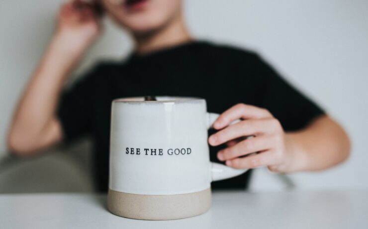 femme en chemise noire tenant une tasse en céramique blanche positif bon