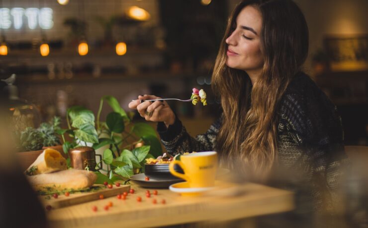 femme tenant une fourchette devant une table