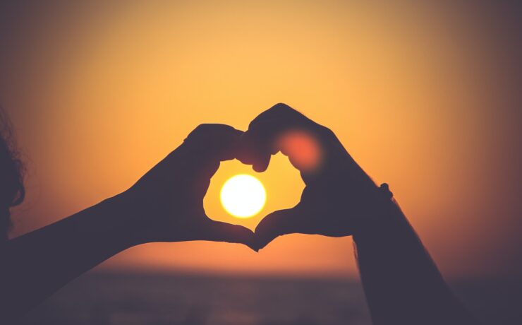 silhouette des mains d'une personne formant un cœur