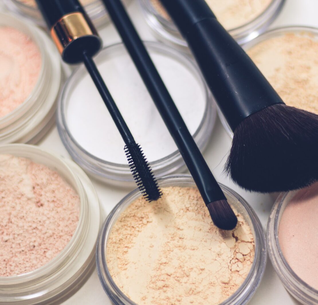 trois pinceaux de maquillage sur des poudres compactes