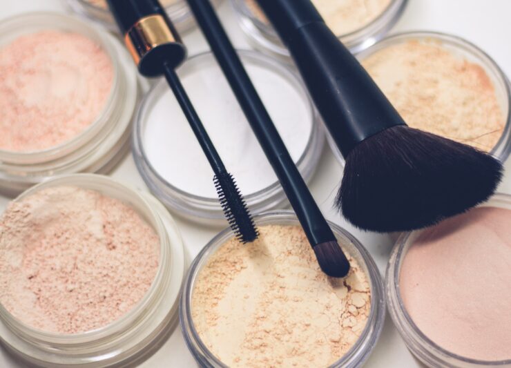 trois pinceaux de maquillage sur des poudres compactes