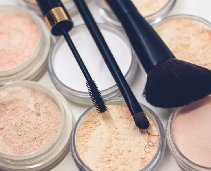 trois pinceaux de maquillage sur des poudres compactes