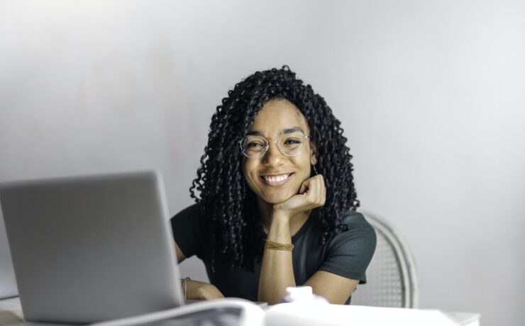 Happy ethnic woman sitting at table with laptop girl smile kind