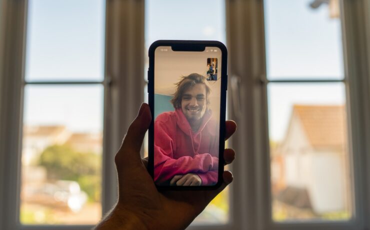 person holding black iphone 5 videocall friend boy man