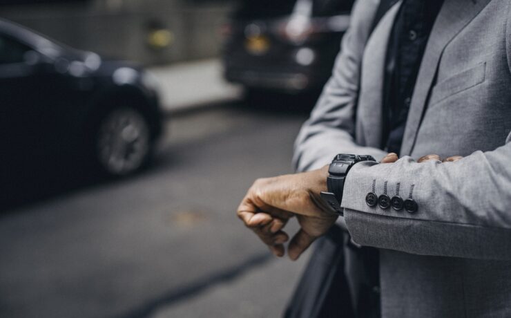 Homme dans la rue en ville regardant l'heure. Horloge, ponctualité