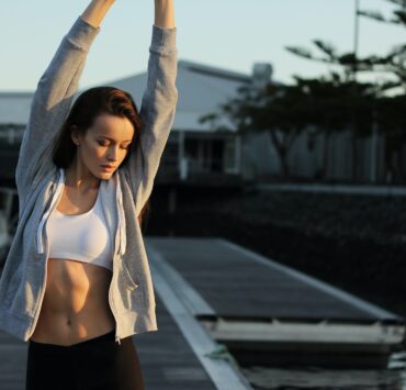 femme en tenue de sport s'étirant en plein air