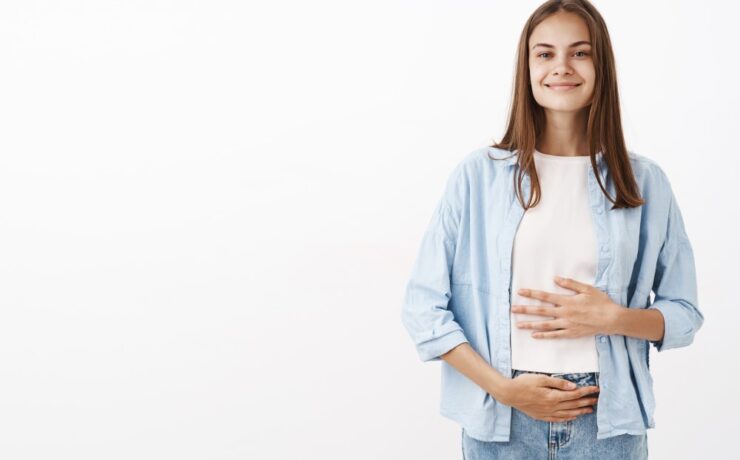 Femme souriante avec l'estomac qui se sent bien après la digestion