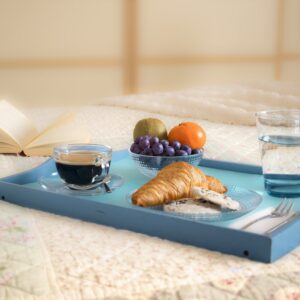 plateau bleu sur une table avec croissant, café, verre d'eau