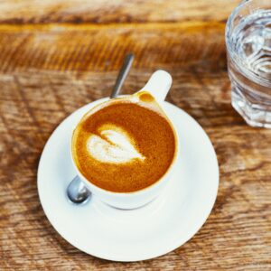 tasse de café avec un verre d'eau sur une table en bois