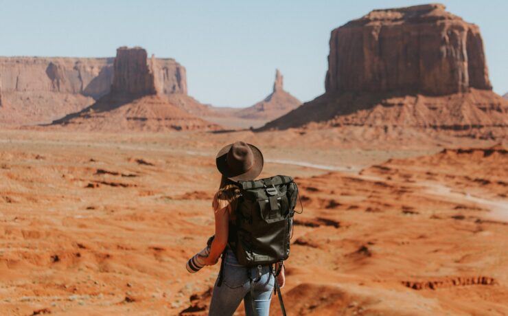 femme avec sac à dos noir debout dans le désert