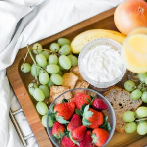 variété de fruits avec yaourt ou fromage sur un plateau en bois