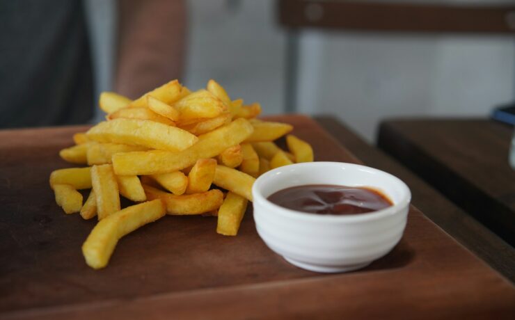 un bol de frites et de sauce sur une table en bois